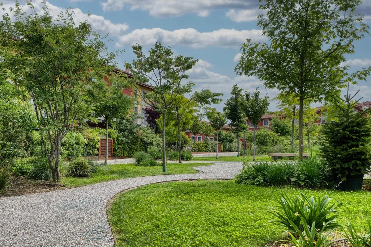 Shared amenity: A landscaped outdoor courtyard with a curved gravel path and surrounding greenery.