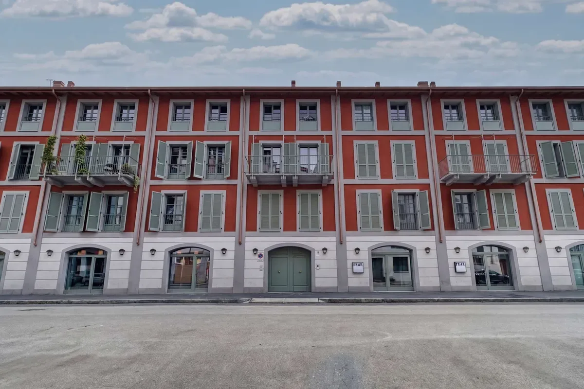 Shared amenity: A row of red and white buildings faces a broad paved area.