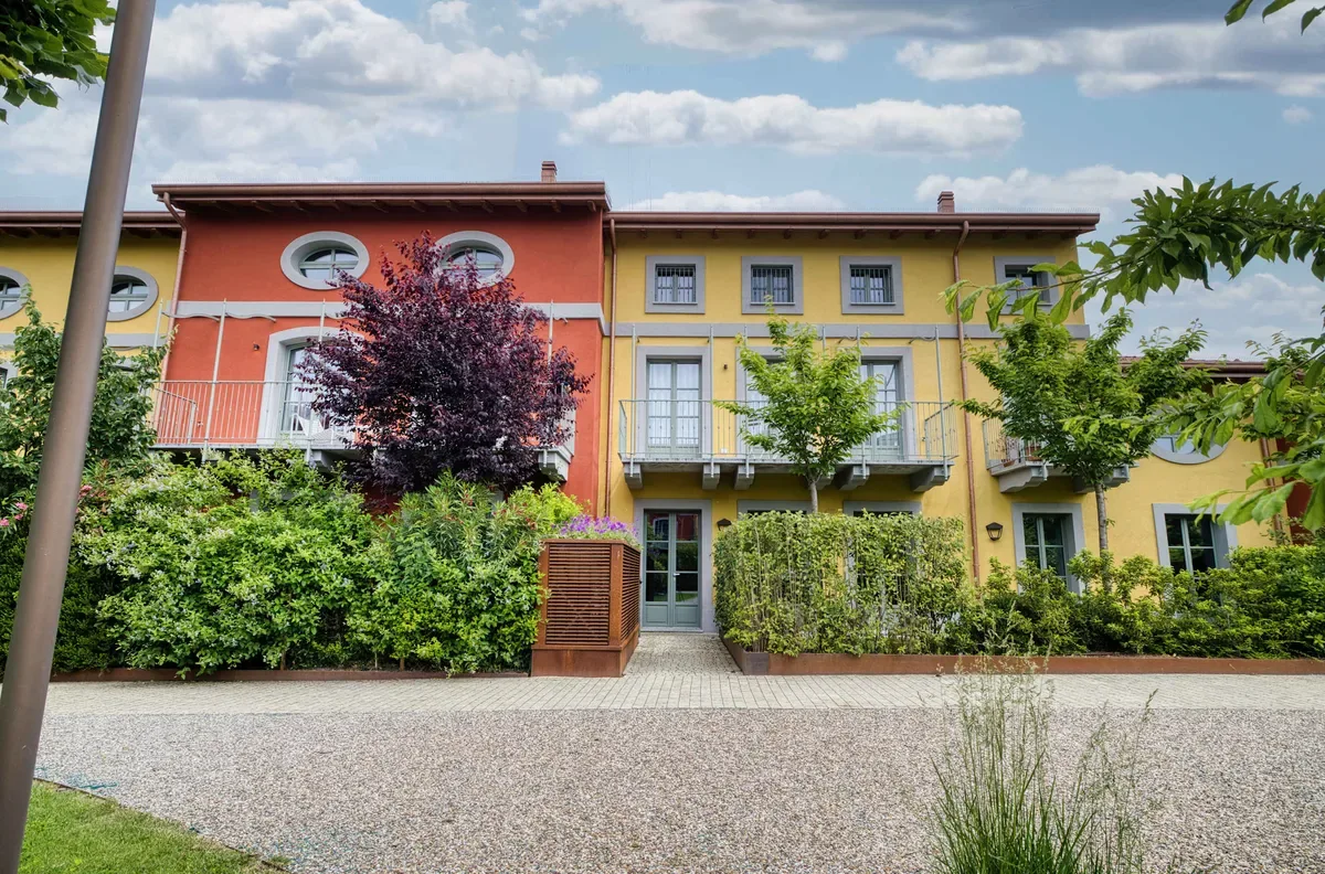Shared amenity: A colorful residential building stands behind a landscaped courtyard.