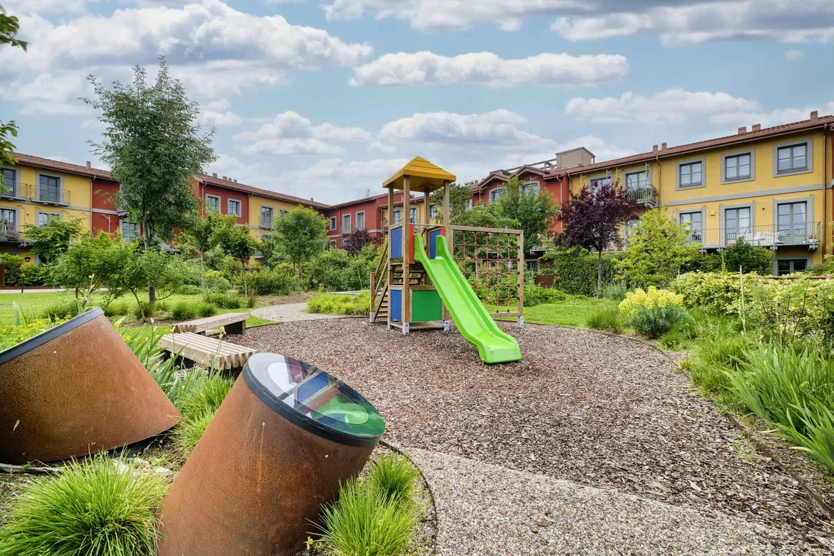 Shared amenity: Outdoor playground with a green slide in a landscaped courtyard.