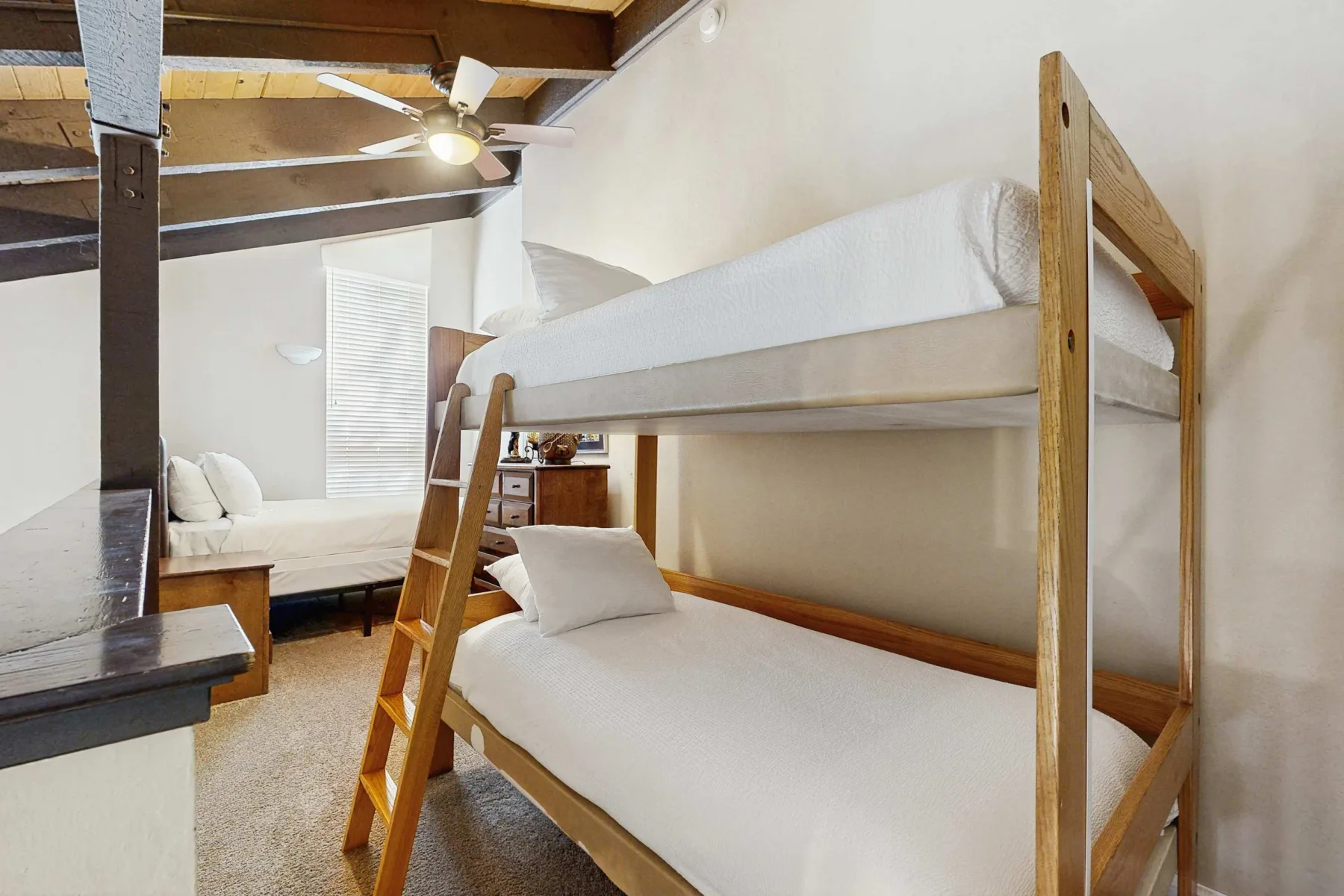 Un dormitorio con una litera de madera y asientos adicionales.