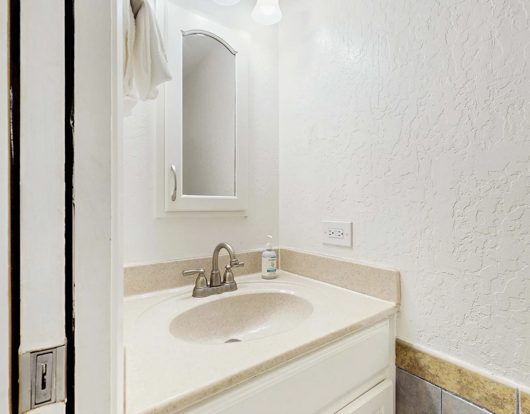 Un lavabo de baño con grifo y espejo en la pared.