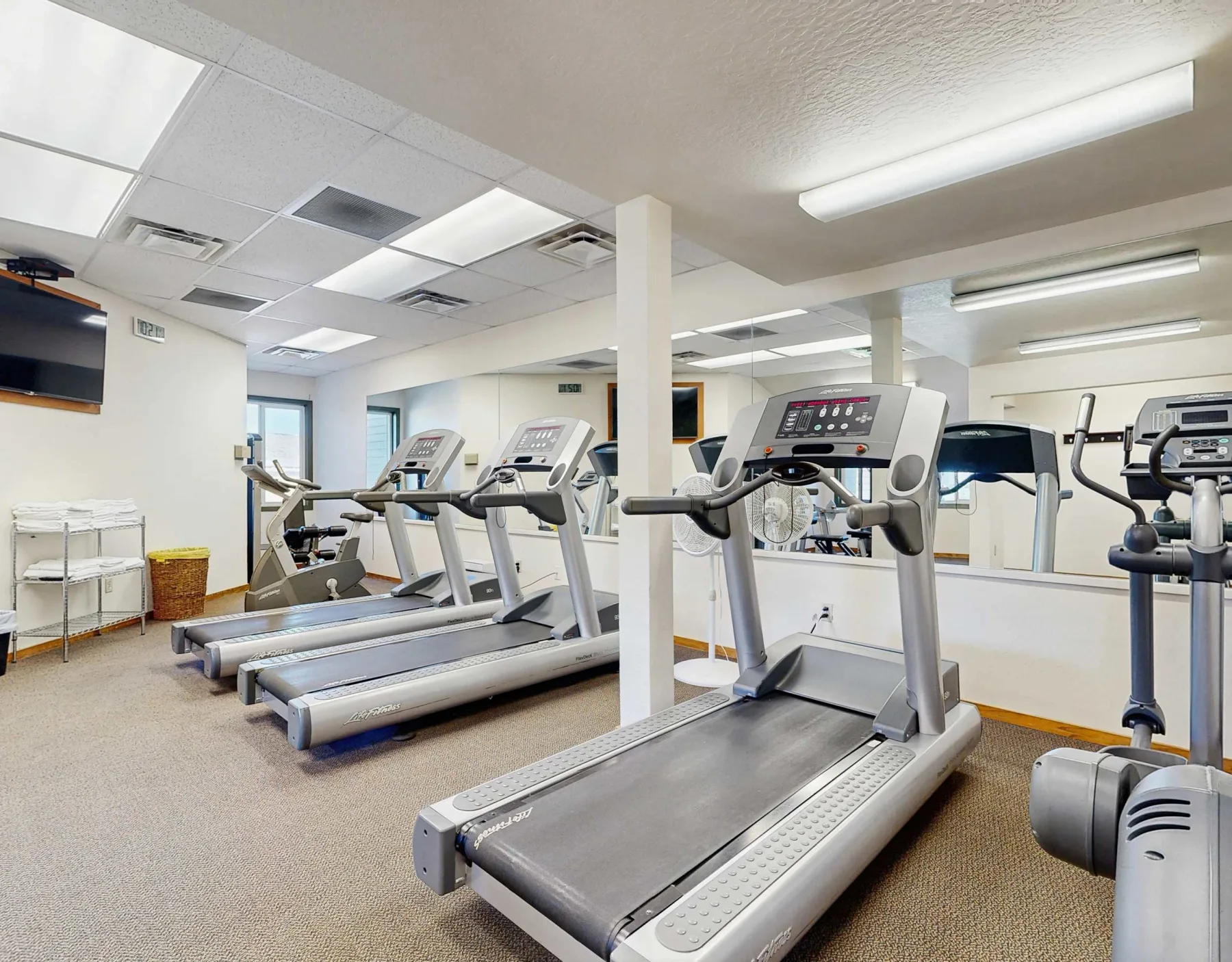 Zona común: Sala de ejercicio con cintas de correr y otros equipos.