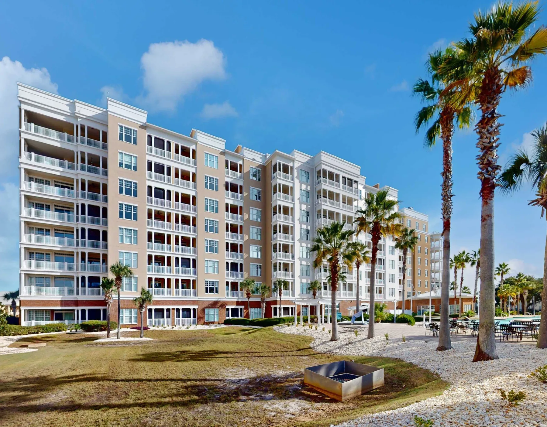 Shared amenity: A multi-story building stands beside a landscaped outdoor area with palm trees.