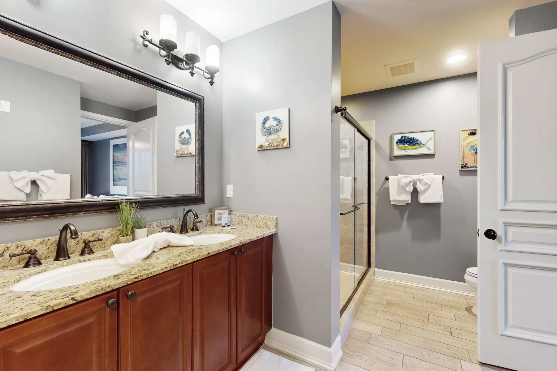 A bathroom vanity with a sink and mirror opens onto a shower area.