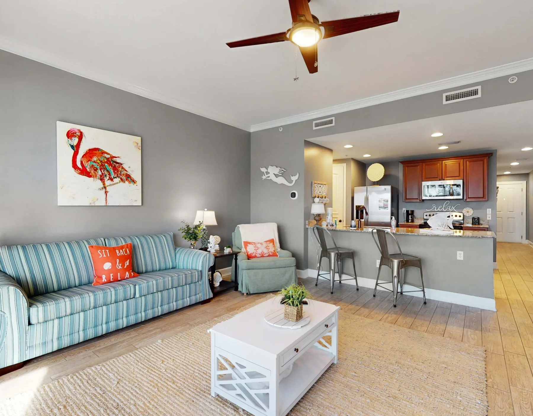 A living room opens into a kitchen, with seating and a coffee table in front.