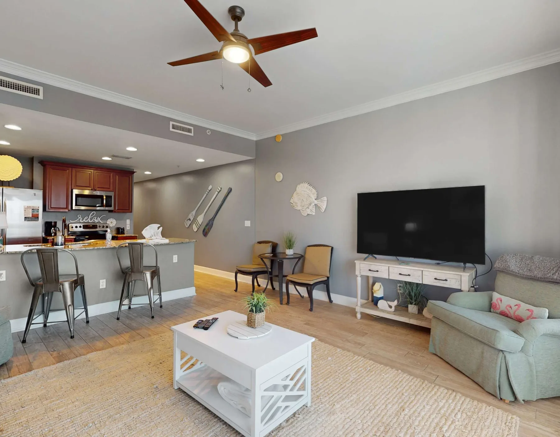 A living room with seating, a coffee table, and an open kitchen area.