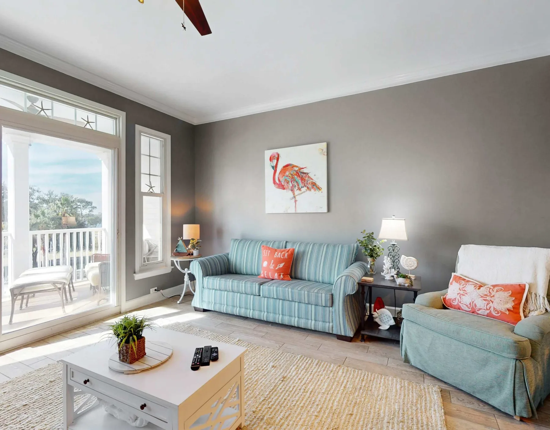 A bright living room with a striped sofa, an armchair, and a coffee table.
