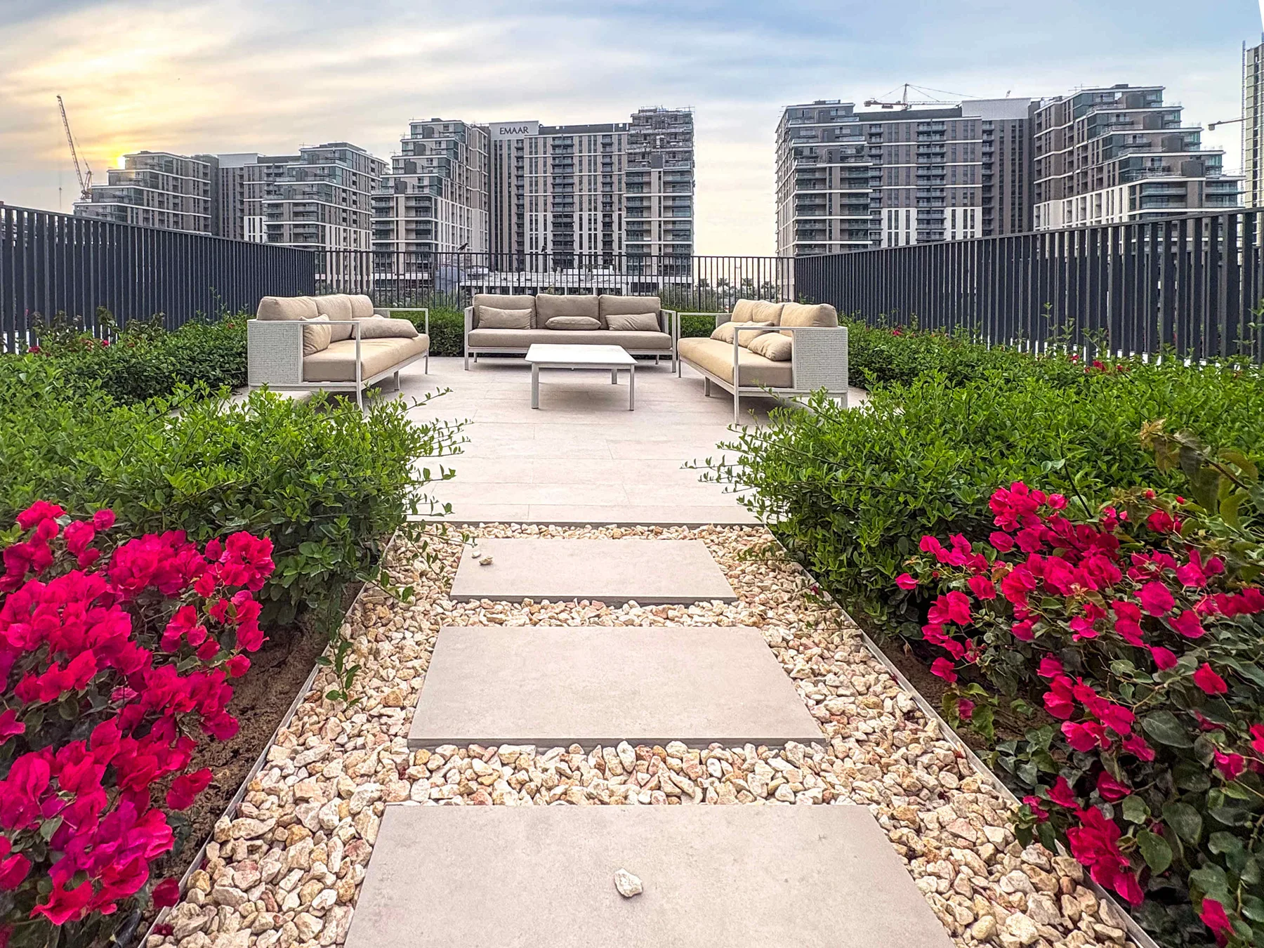 Shared amenity: A rooftop garden patio with outdoor seating and bright flower beds.