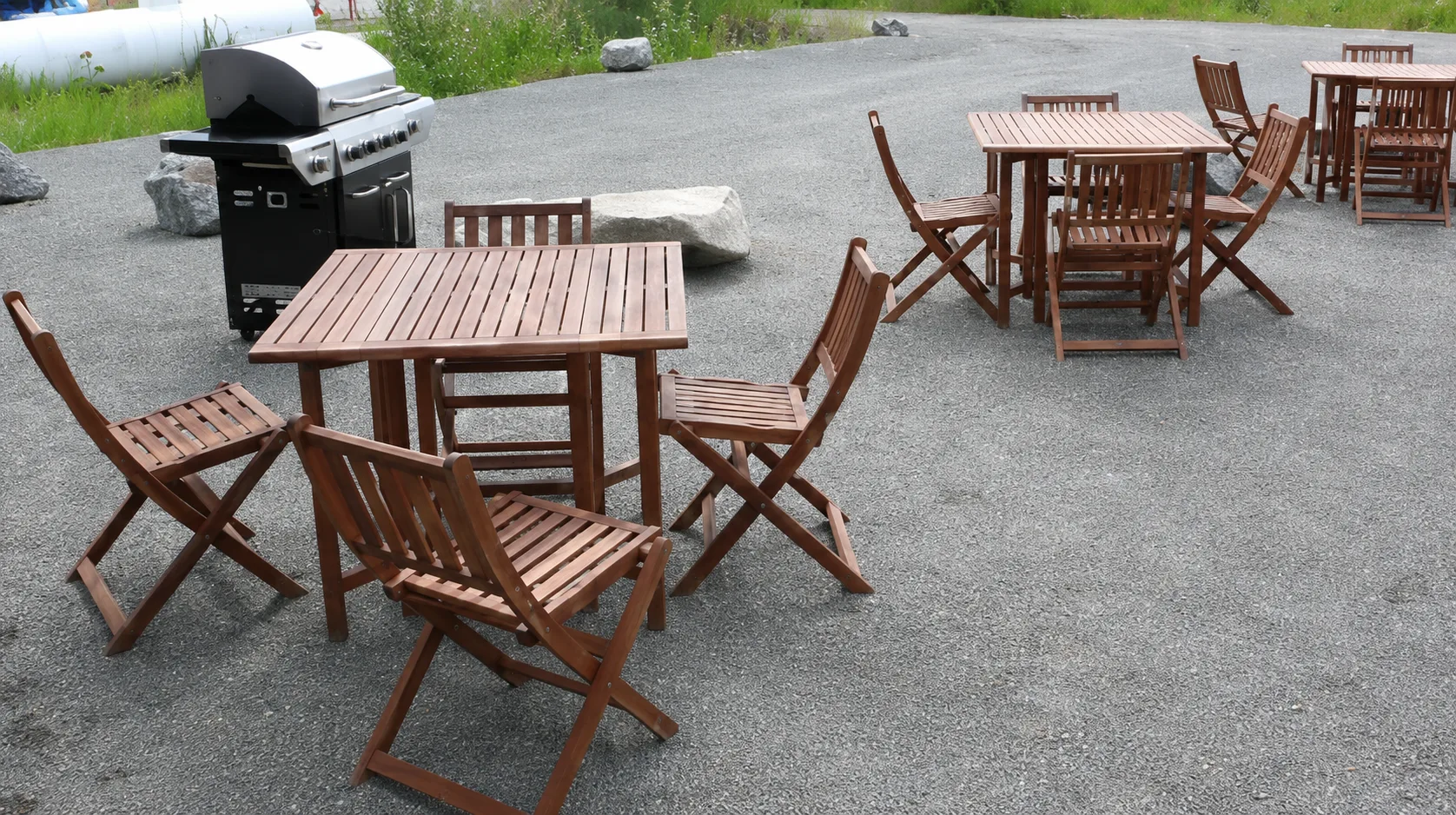 Representative hotel space: Outdoor patio seating with wooden tables and a grill.