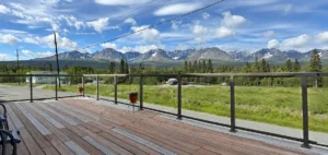 Representative hotel space: An outdoor wooden deck overlooks a grassy landscape and distant mountains.