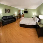 Representative hotel space: A bedroom with a bed, a sofa, and a television.