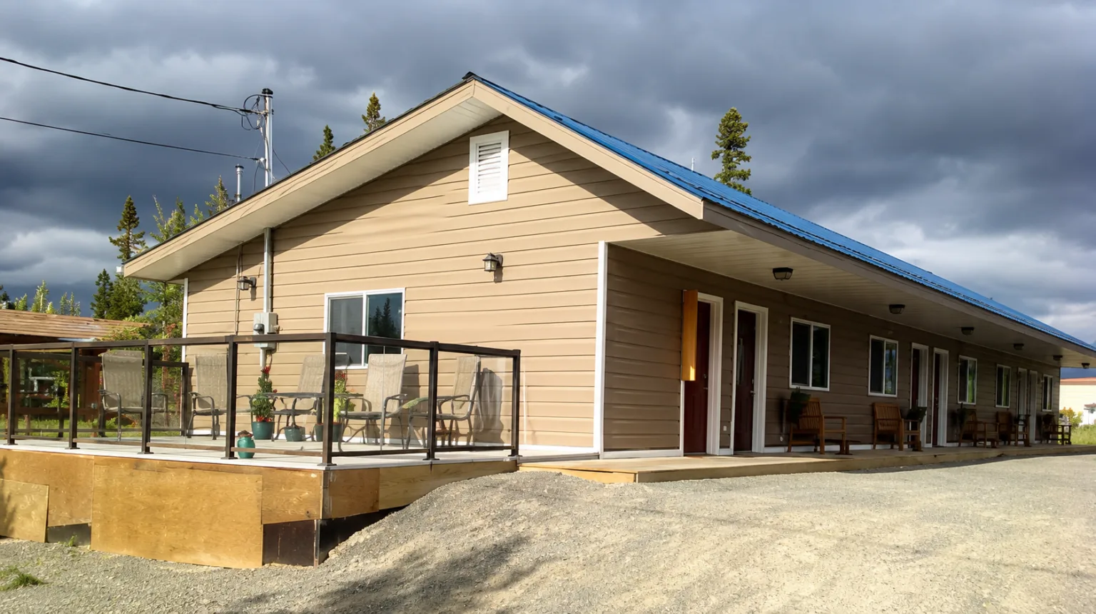 Representative hotel space: A low, tan-sided building has a covered entrance and an outdoor seating area.