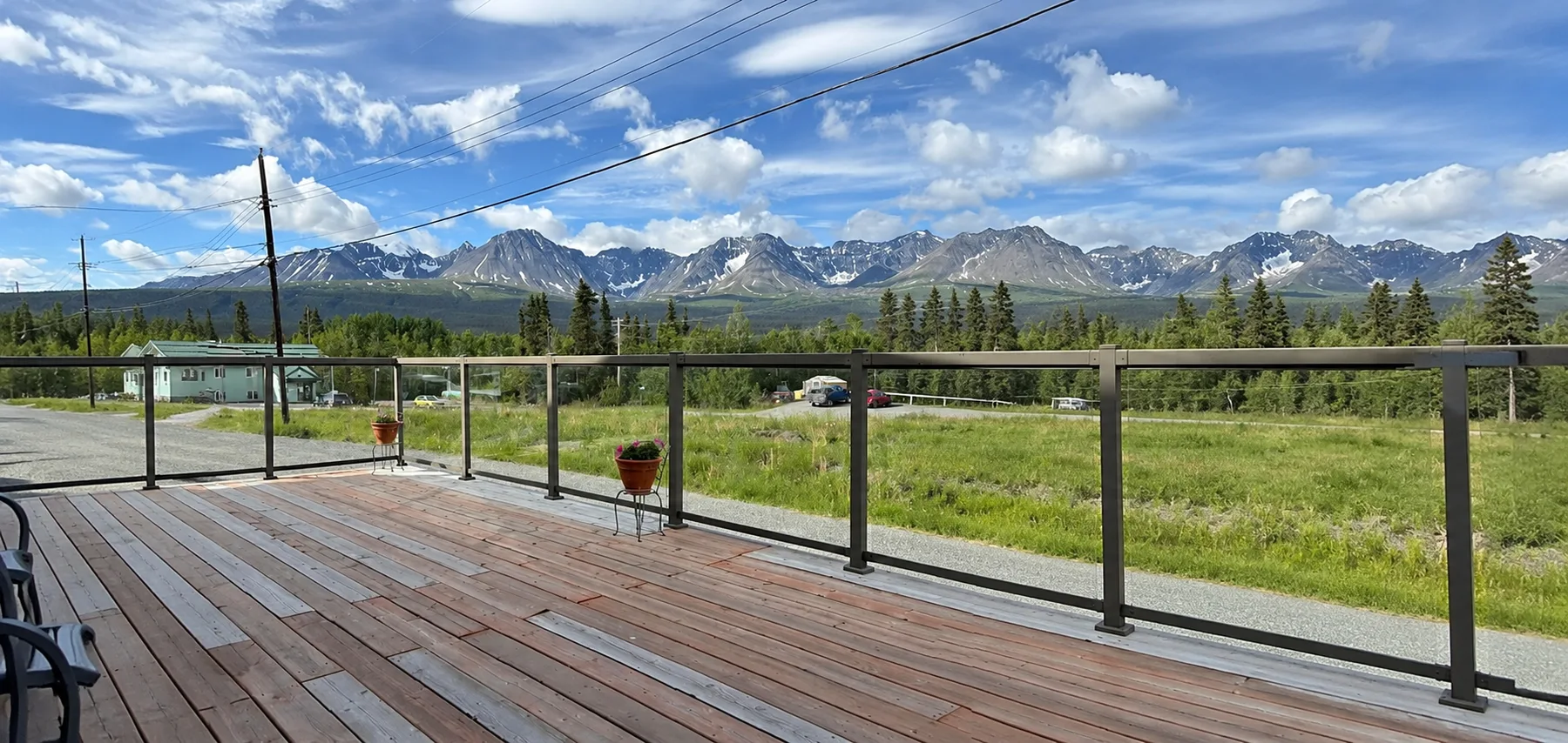 Representative hotel space: A wooden deck overlooks a grassy field and distant mountains.