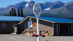 Representative hotel space: A lodge building with a sign stands against a mountain backdrop.