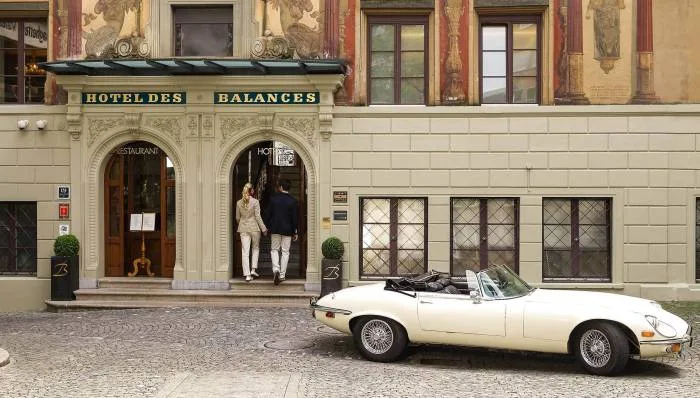Representative hotel space: Hotel entrance with ornate stone arches and a white convertible parked outside.