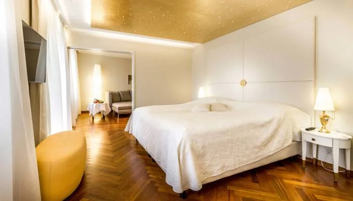 Representative hotel space: A bedroom with a large bed and warm wood flooring.