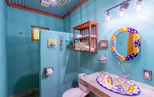 Representative hotel space: A colorful bathroom with a tiled vanity and decorative mirror.