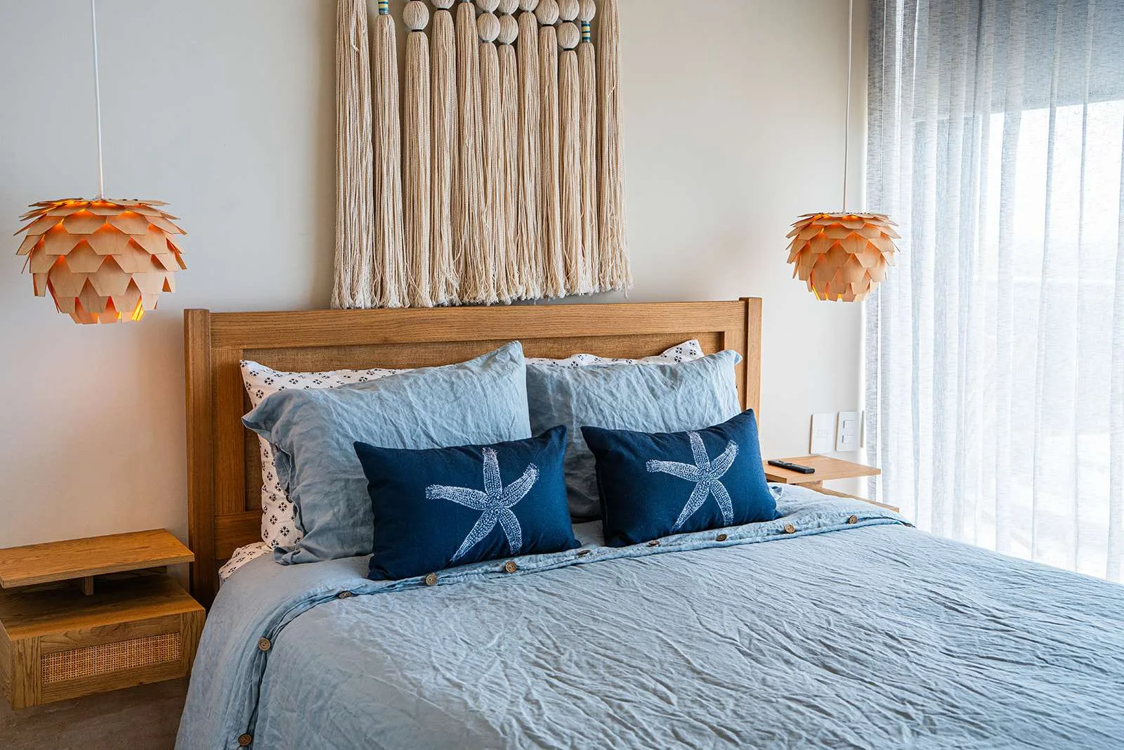 Un dormitorio con una cama tendida y cojines decorativos azules.