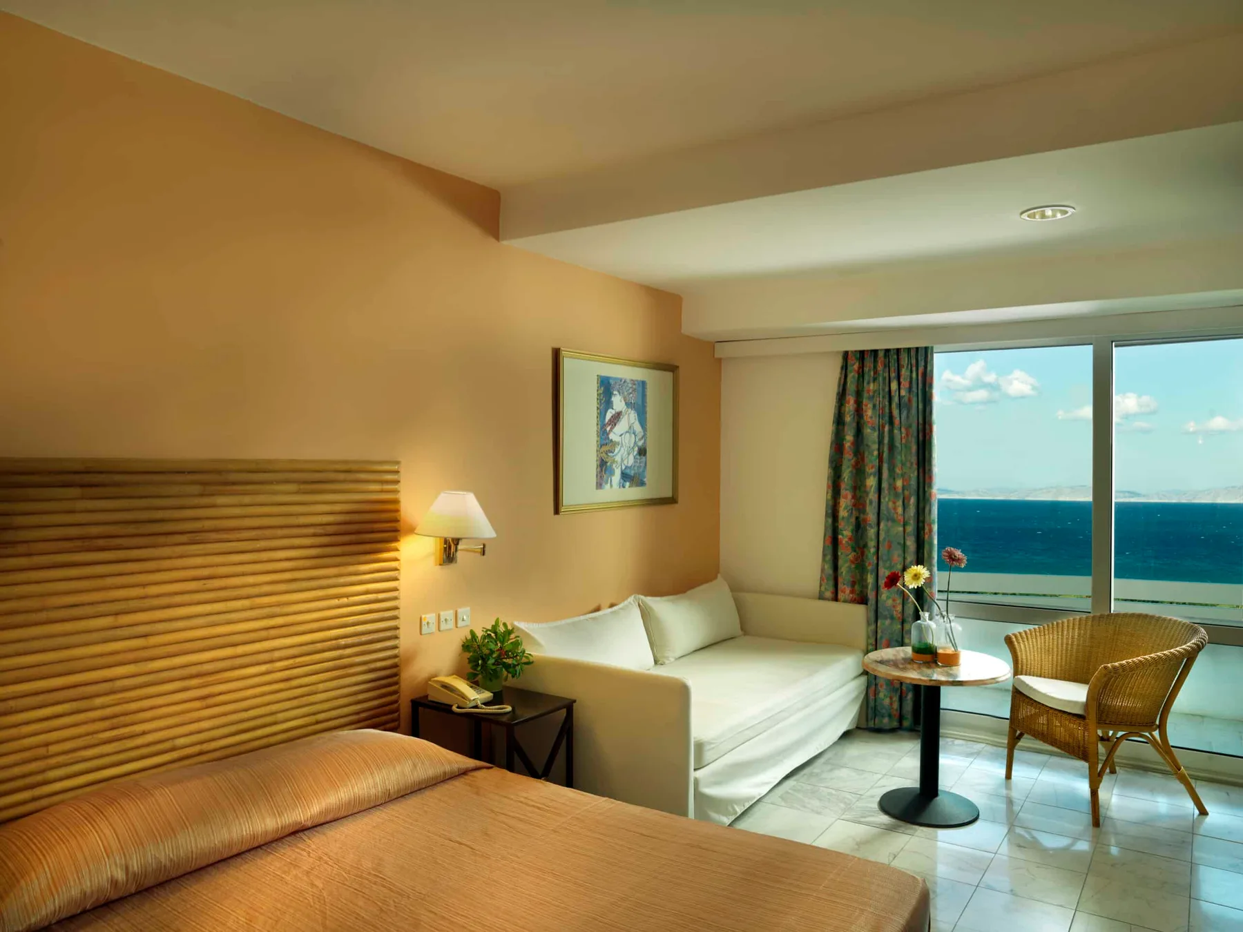 Espacio representativo del hotel: Habitación de hotel con una cama, una zona de estar y una ventana con vistas al mar.
