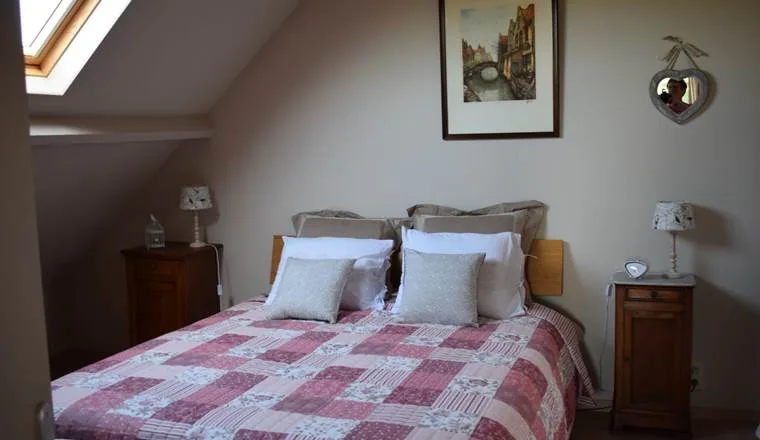 Espacio representativo del hotel: Un dormitorio con una cama bajo un techo inclinado y una claraboya.