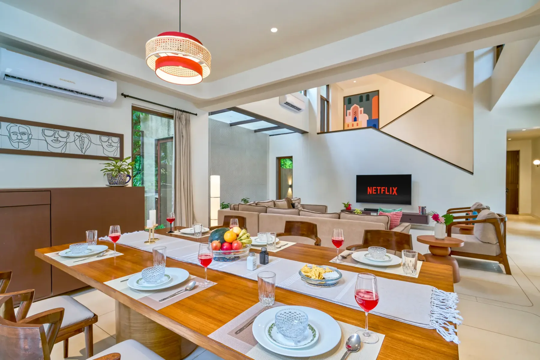 A dining area with a set table beside a living room.
