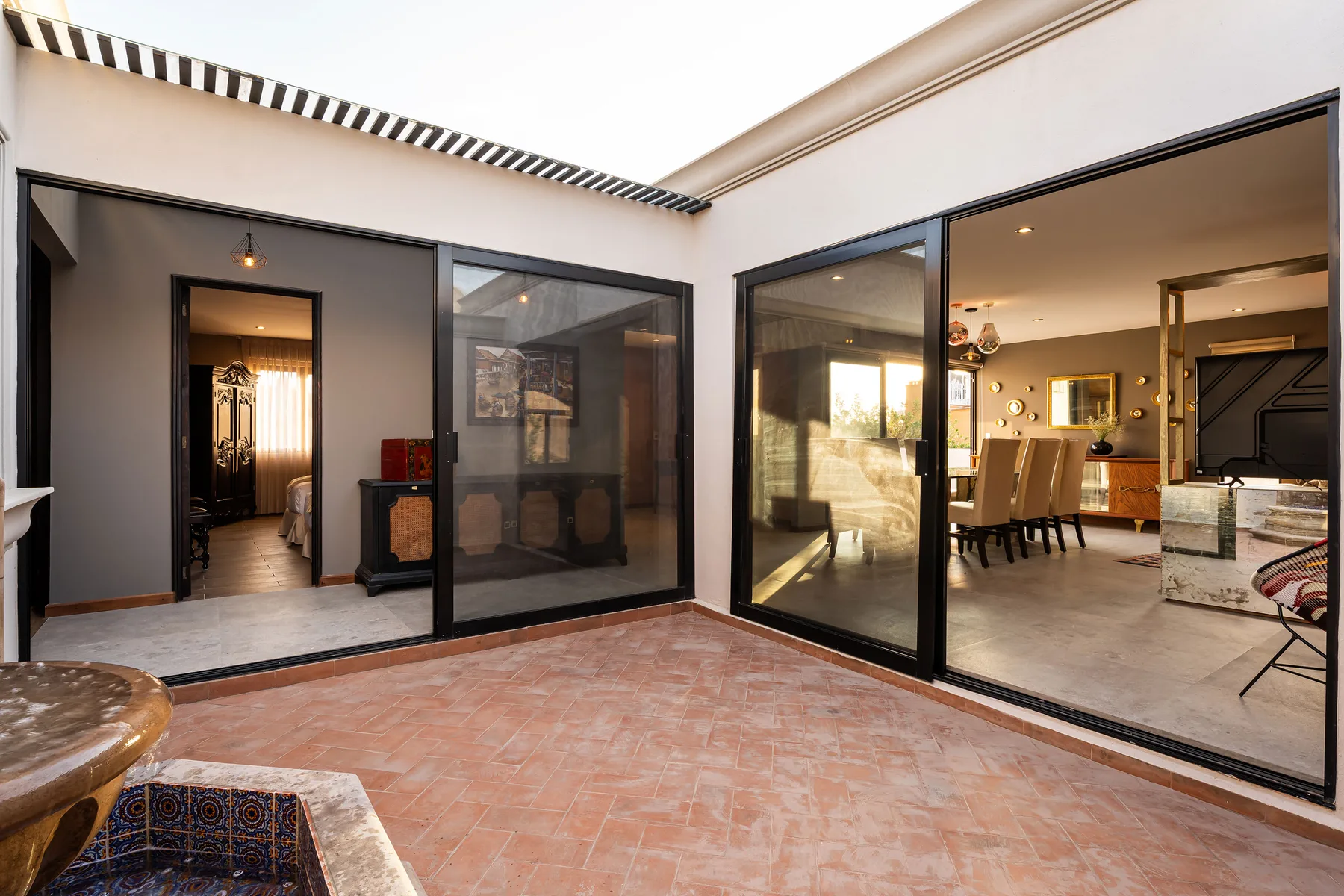 A tiled patio opens through glass doors to a living and dining area.