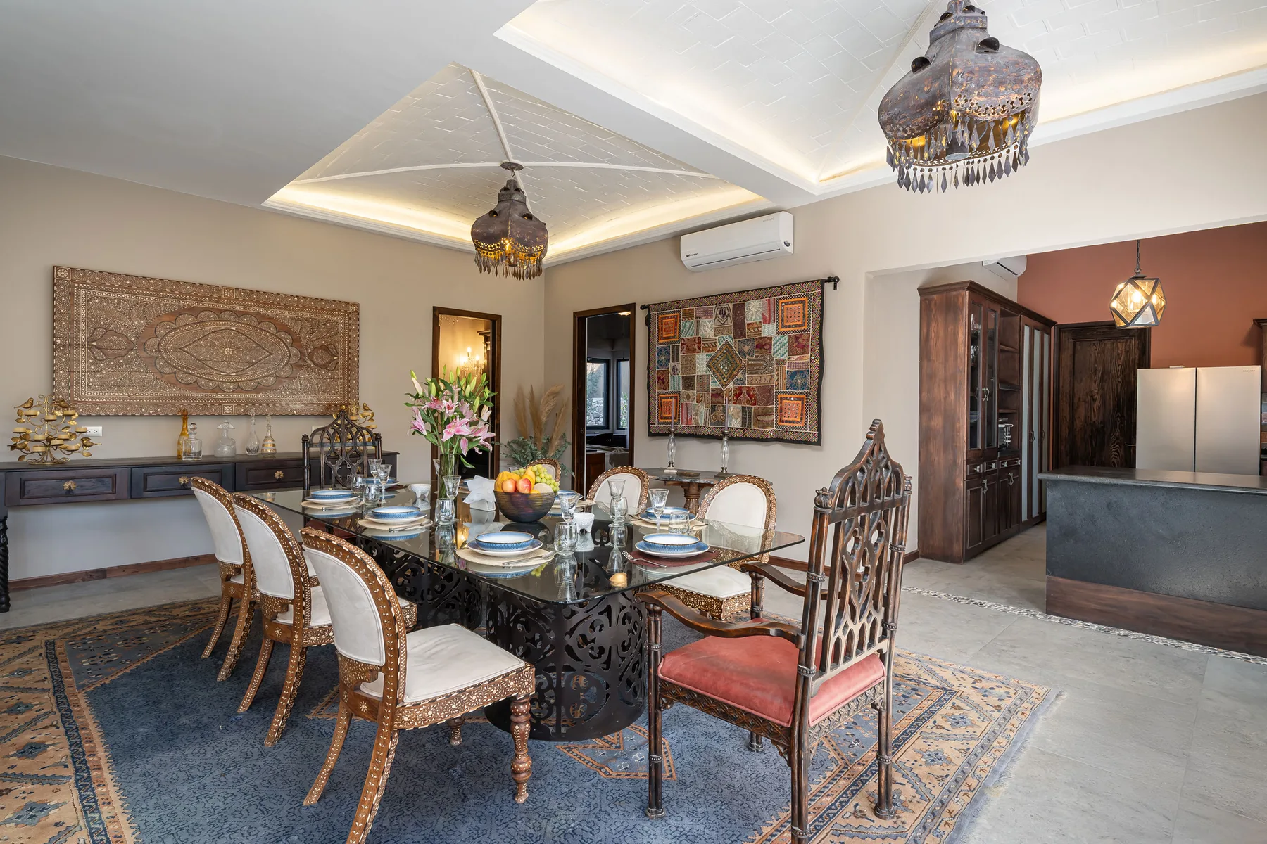 A dining room with a set table and decorative wall hangings.
