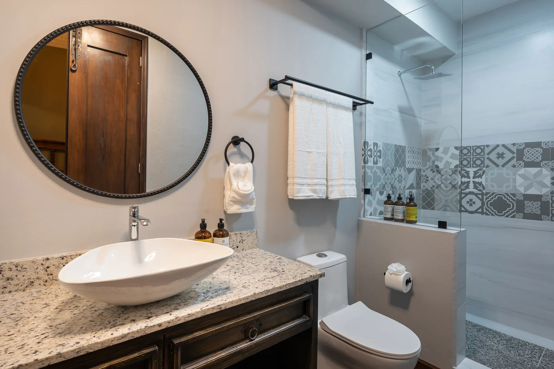 A bathroom with a sink, toilet, and glass shower.