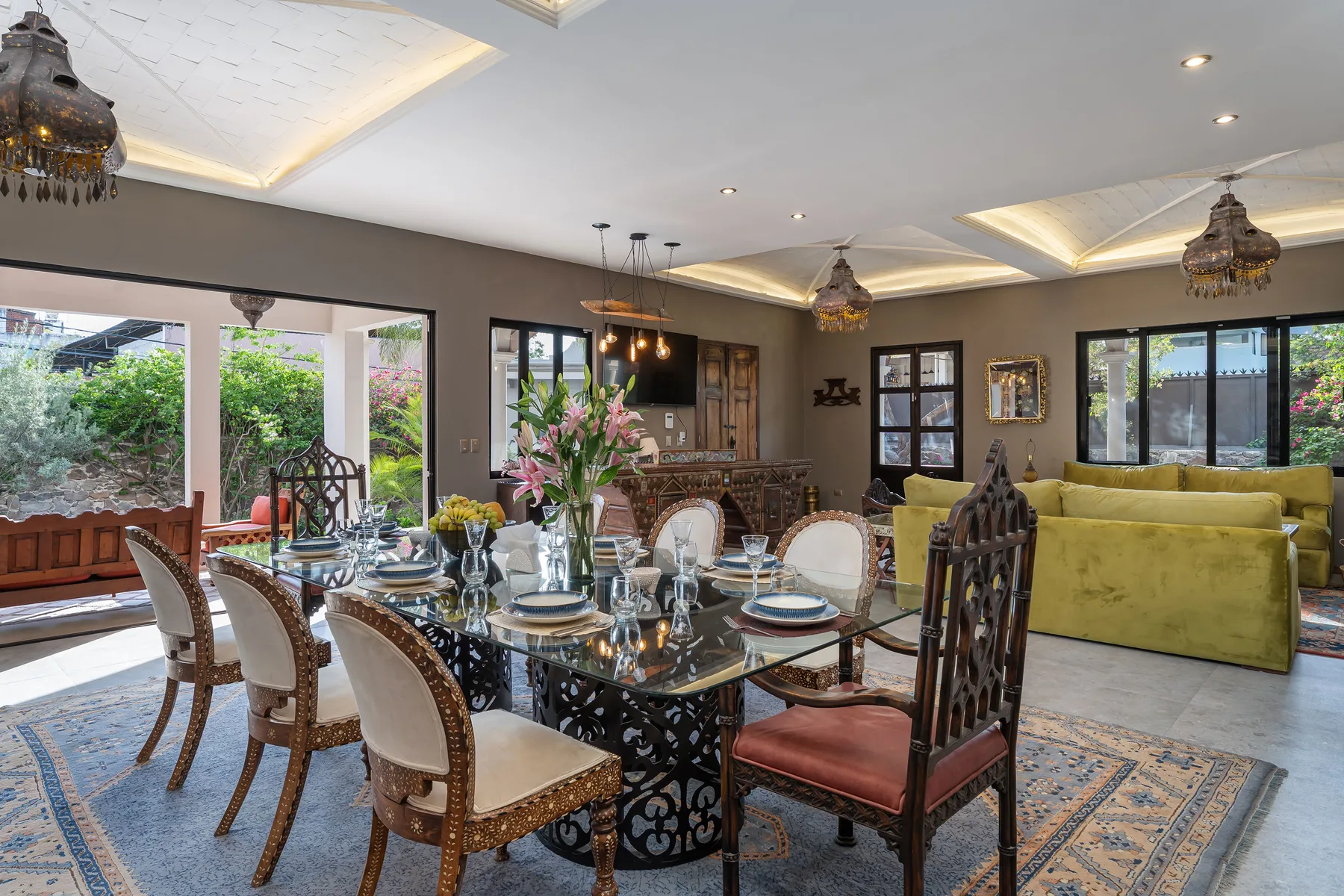 A dining and sitting room with a set table beside a yellow sofa.
