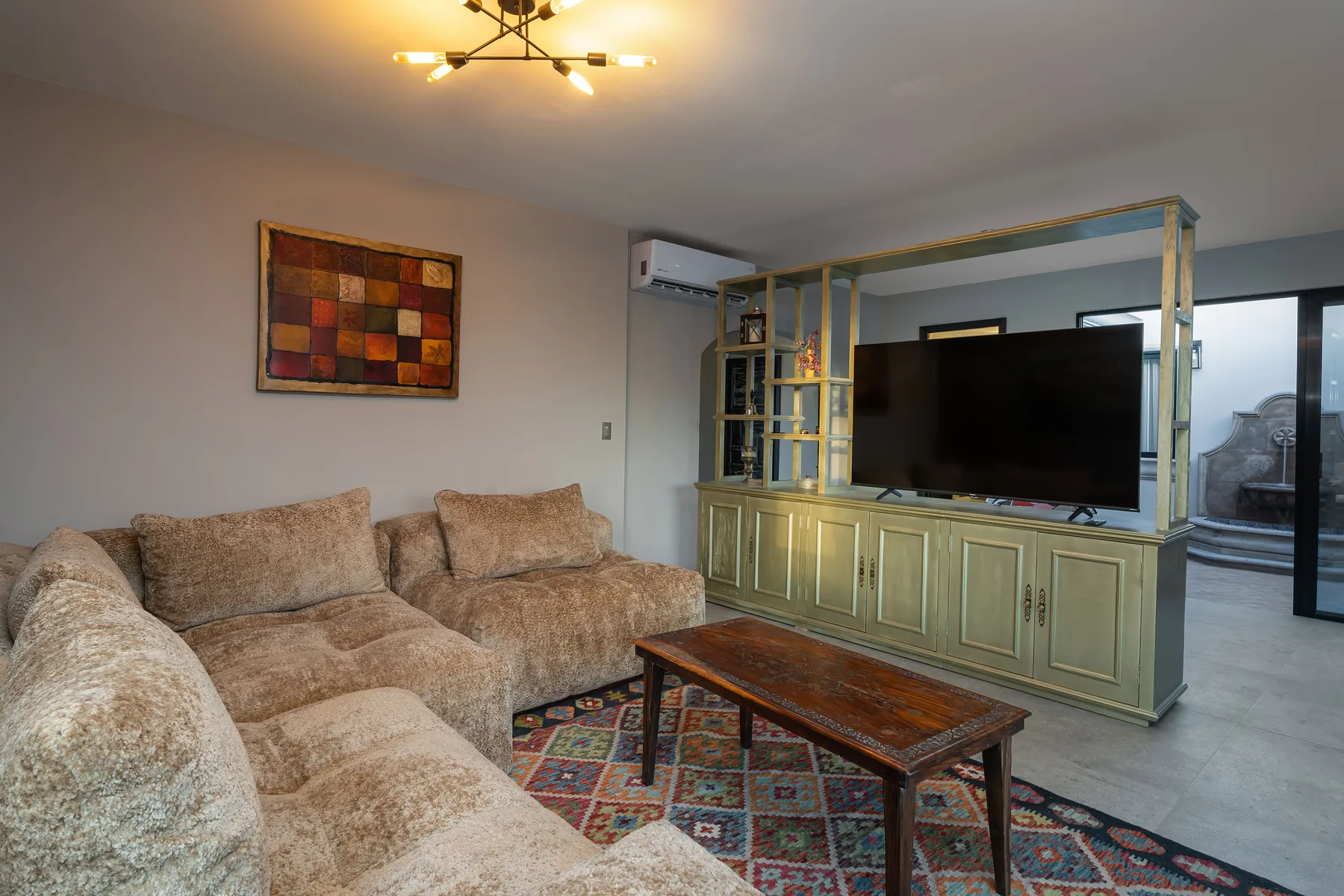 A living room with sectional seating, a coffee table, and a television.