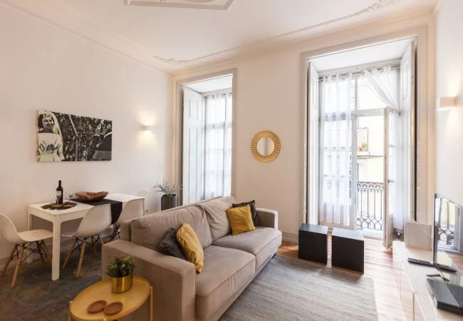 Una sala luminosa con asientos y ventanales altos que dan a un balcón.