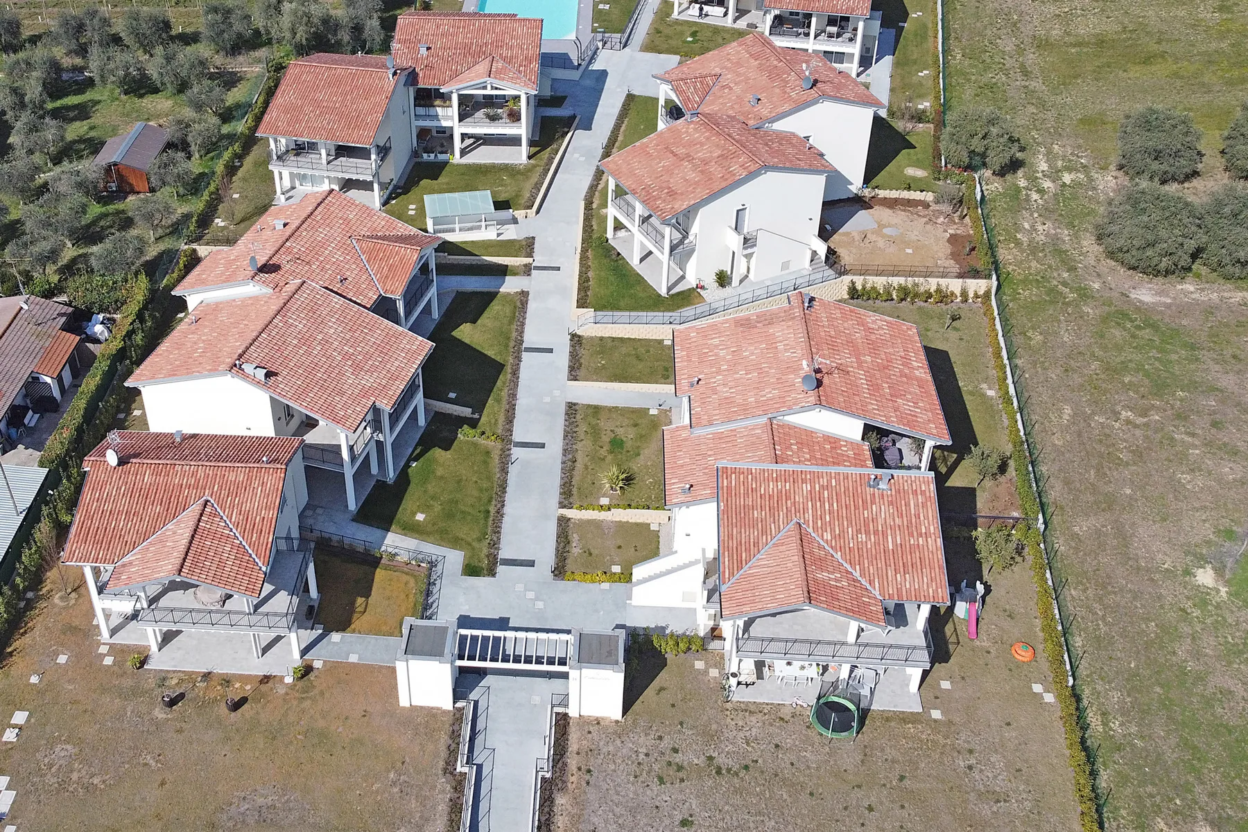 Shared amenity: Aerial view of several houses arranged along a central paved walkway.