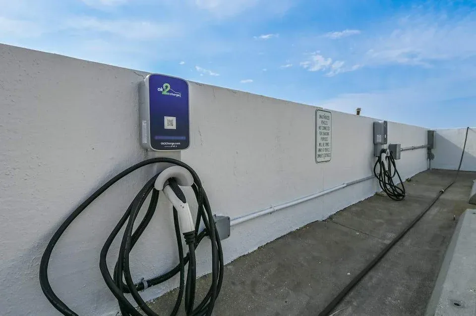 Zona común: Zona exterior con estaciones de carga para vehículos eléctricos instaladas en una pared.