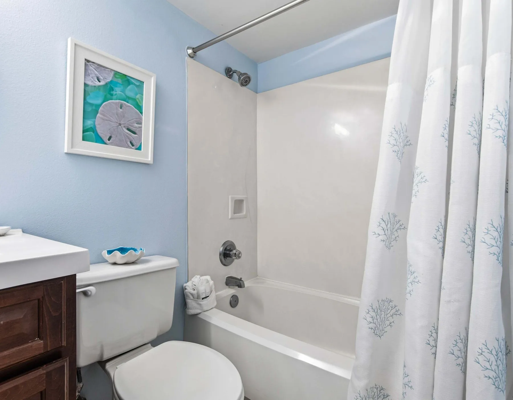 Un baño con bañera, cortina de ducha, inodoro y lavabo.