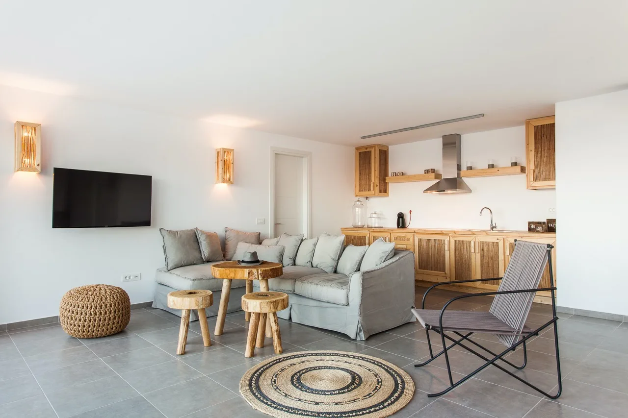 A living area opens onto a kitchen, with a sectional seating area and a television.