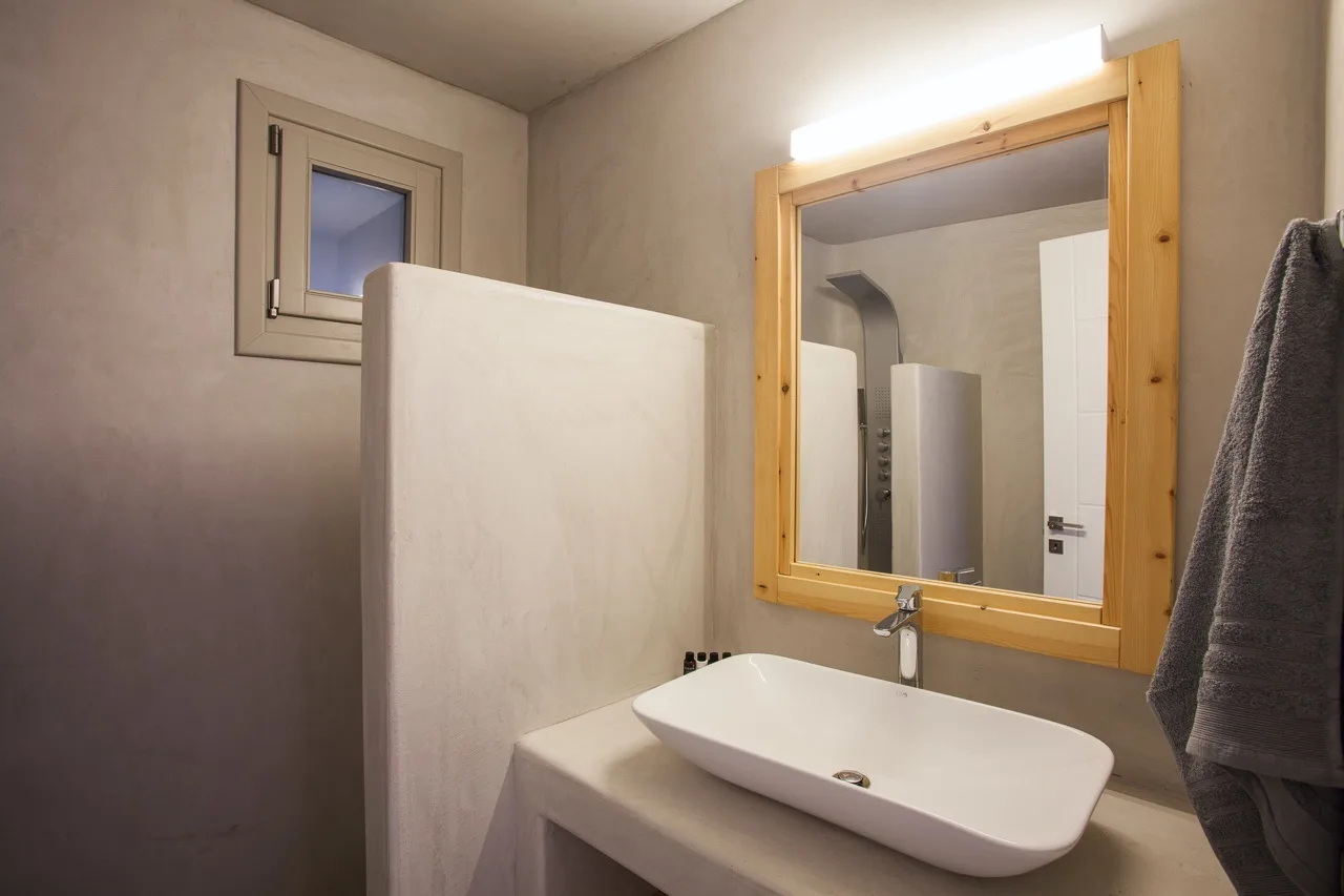 A bathroom vanity with a white basin and a large mirror.