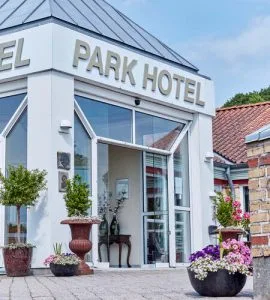 Representative hotel space: Hotel entrance with glass doors and flower planters.