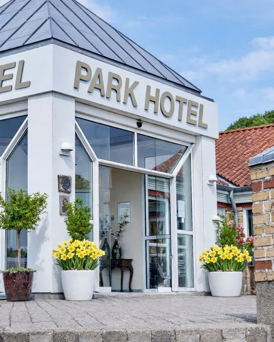 Representative hotel space: The entrance of Park Hotel has glass doors and potted flowers.