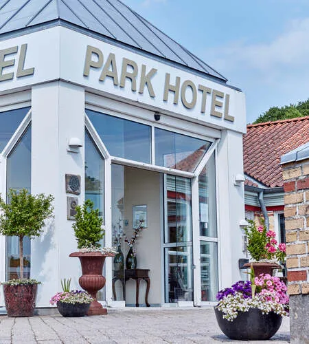 Representative hotel space: The hotel entrance has glass doors and flower planters beside the doorway.
