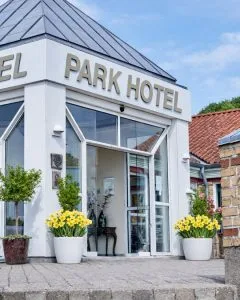 Representative hotel space: A hotel entrance with large windows and flower planters beside the doorway.