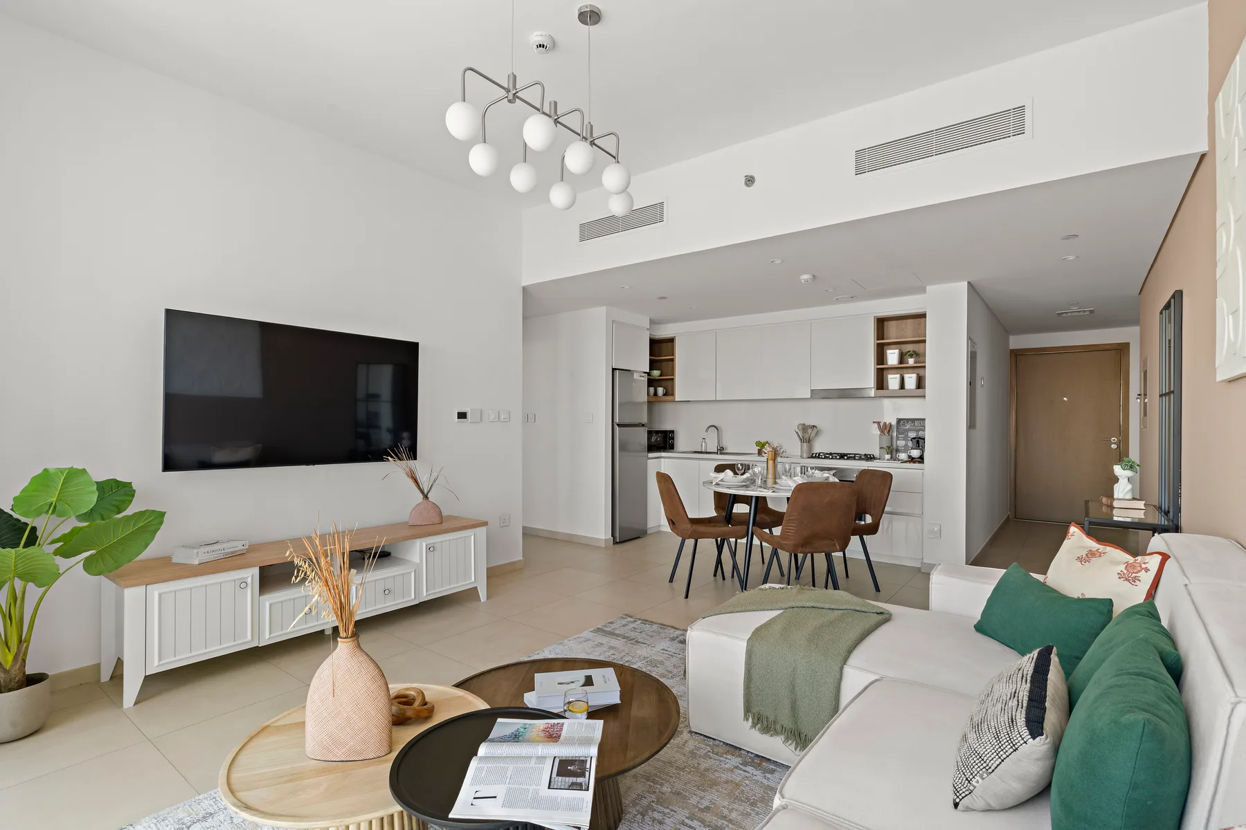 A bright living room opens onto a dining area and kitchen.