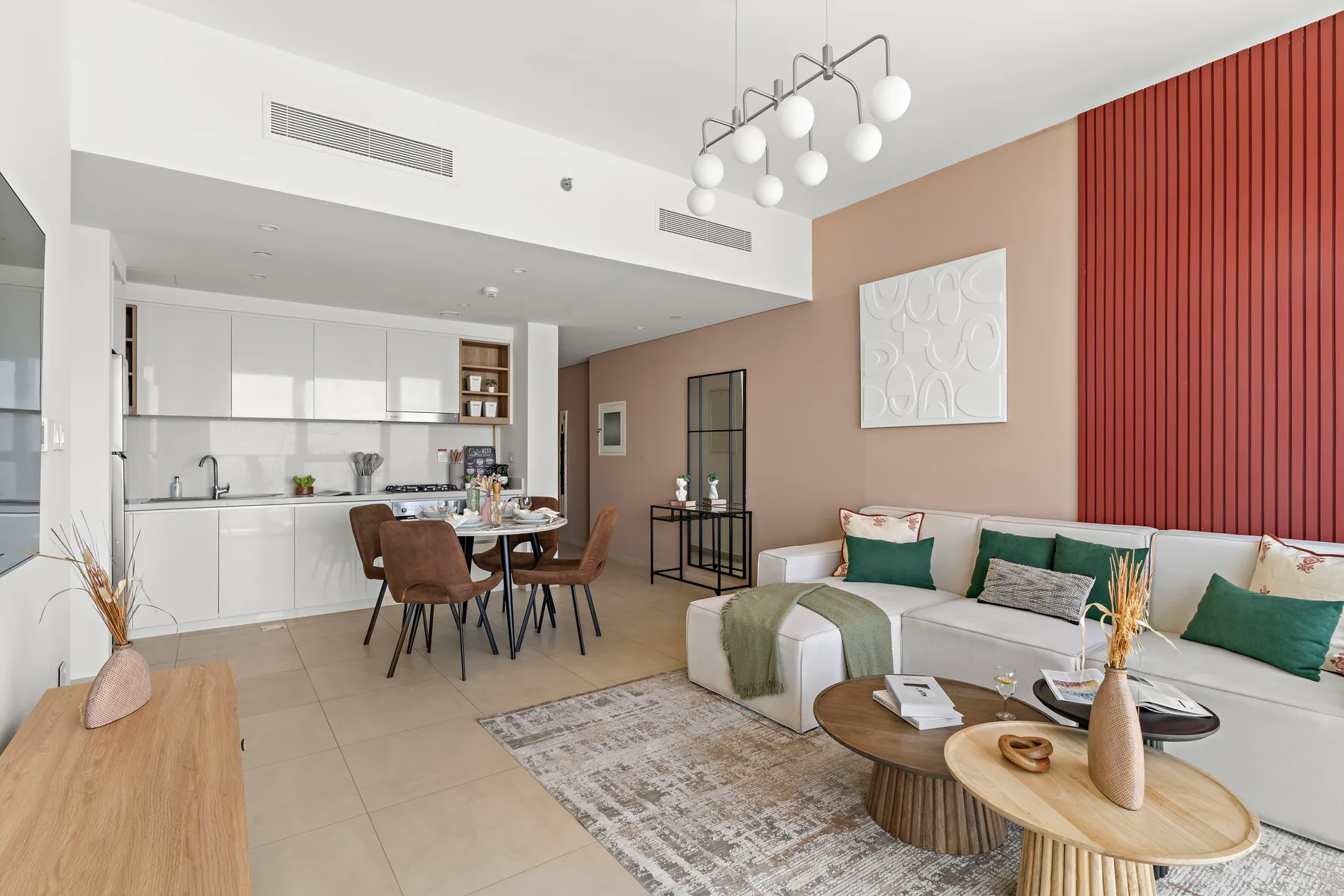 A modern open-plan living and dining area with a white kitchen and green accents.