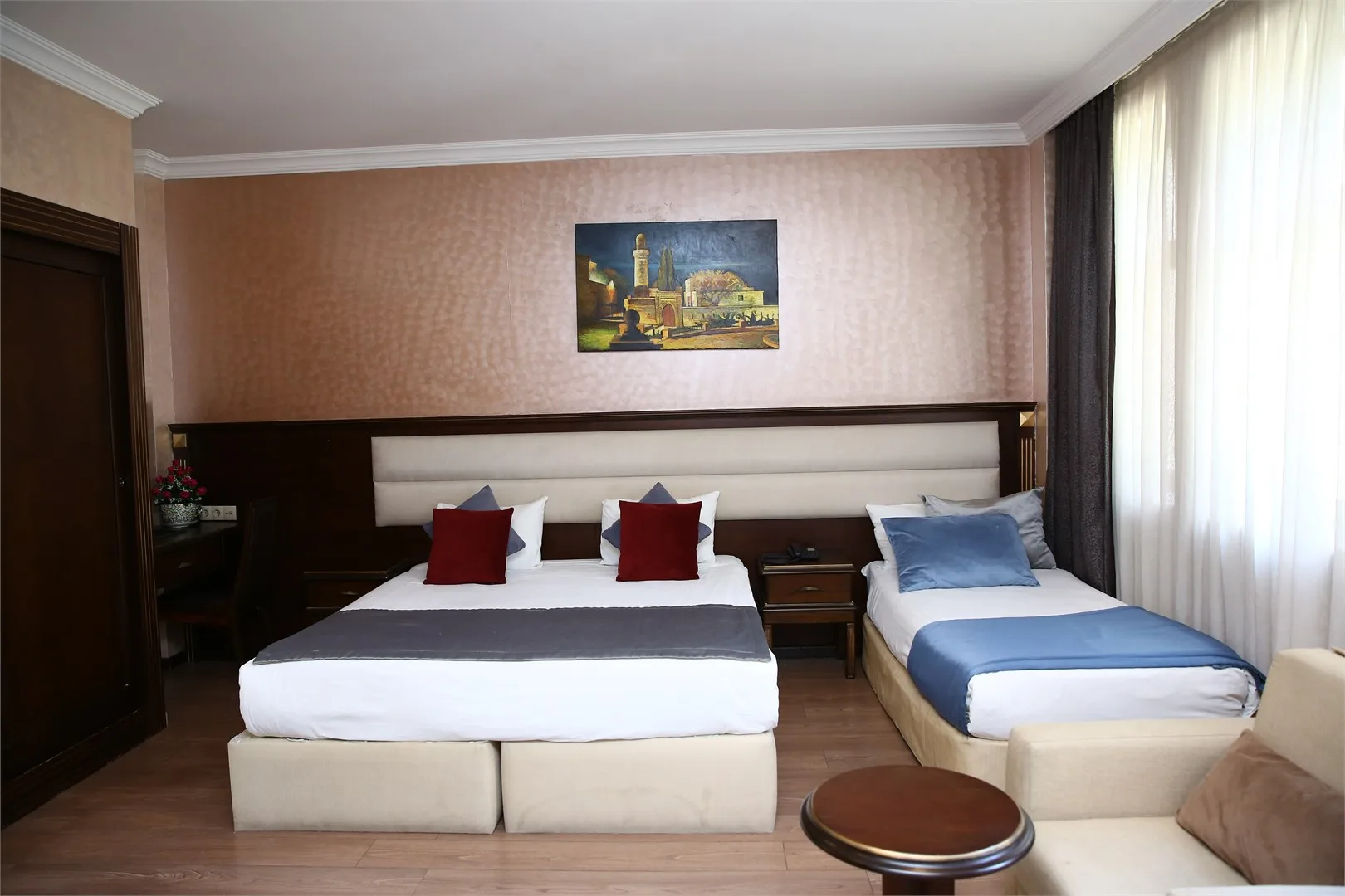 Espacio representativo del hotel: Dormitorio de hotel con dos camas, mesas de noche y una ventana.