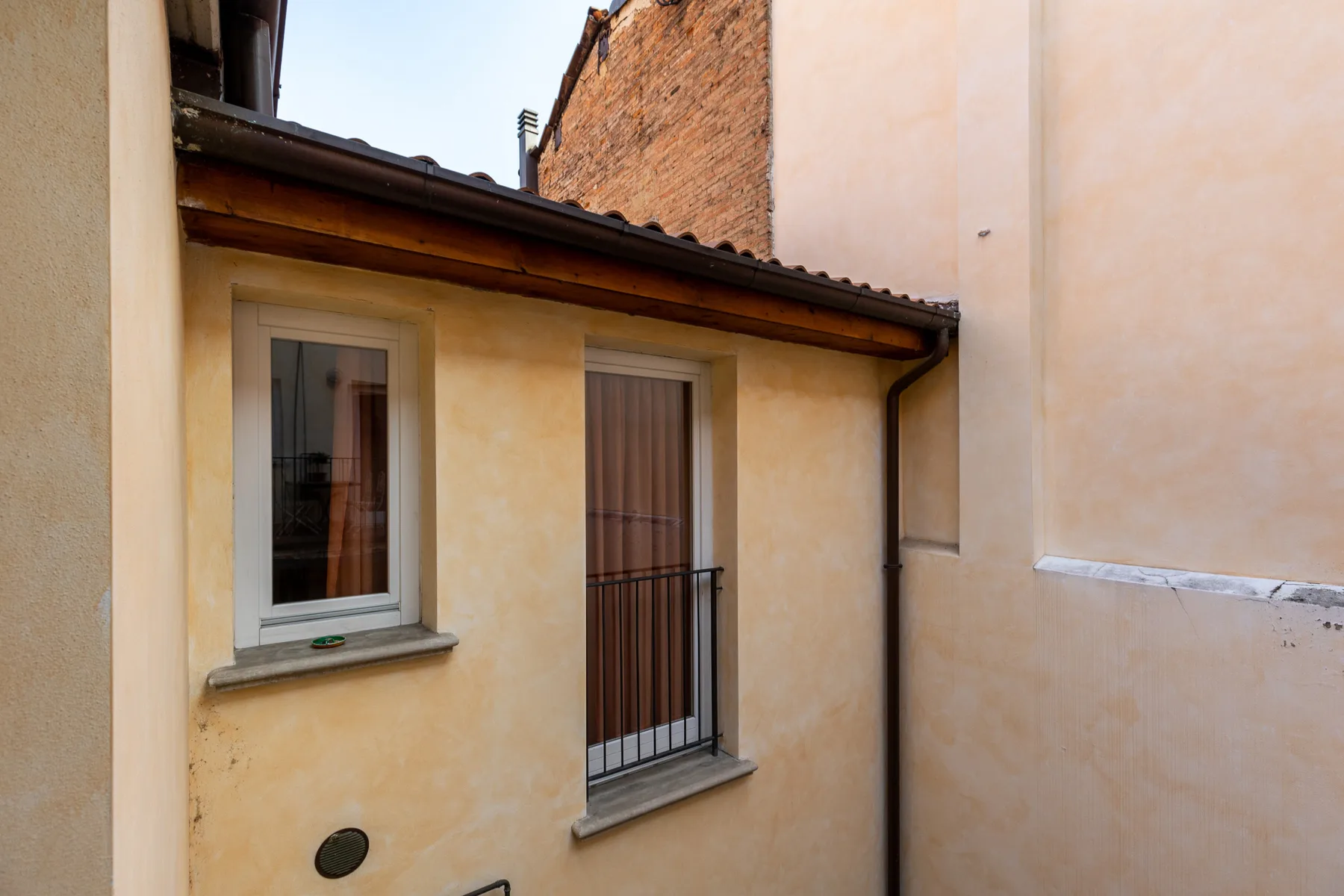 Zona común: Vista exterior de una fachada con ventanas y un pequeño balcón.