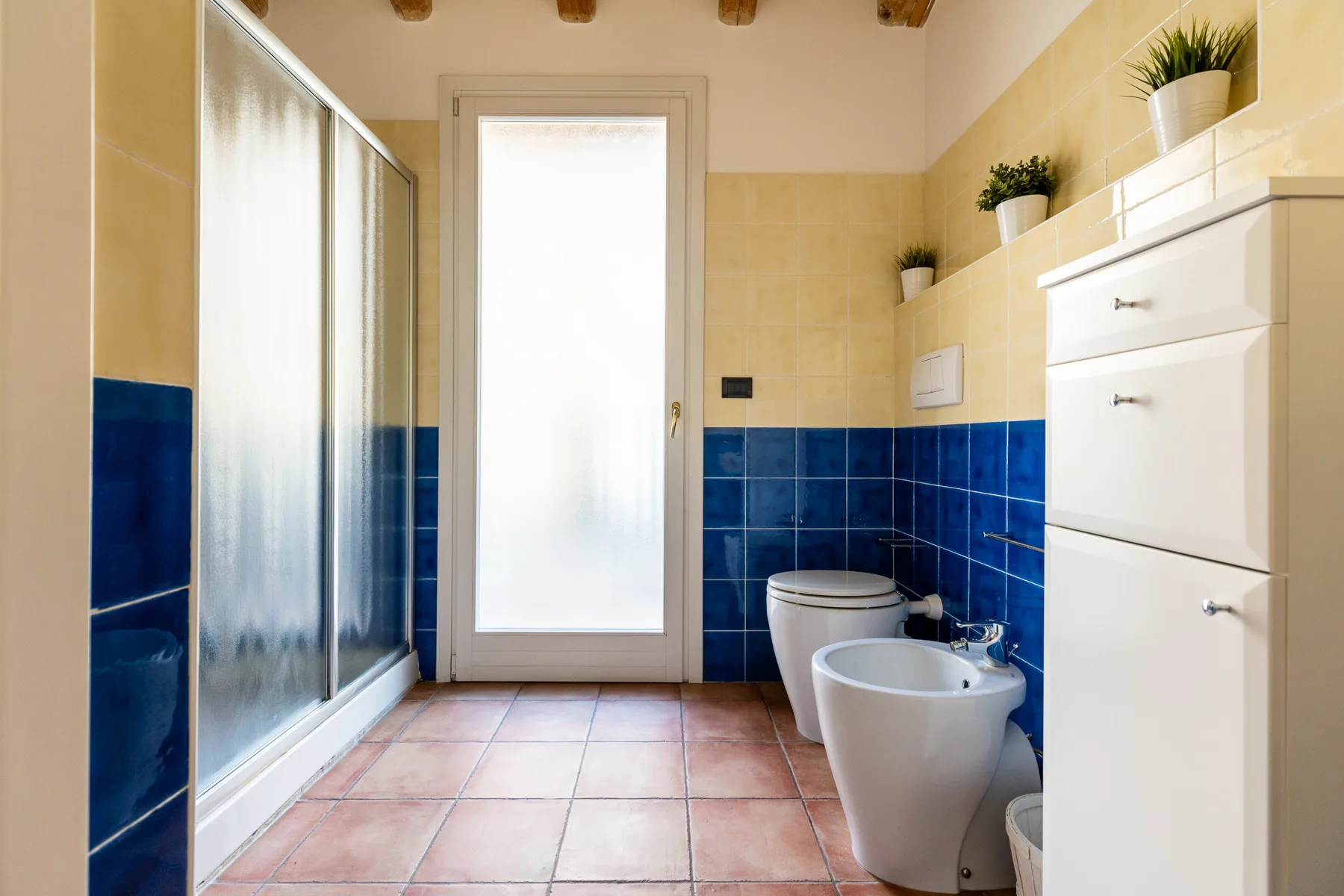 Un baño alicatado con ducha, inodoro y bidé.