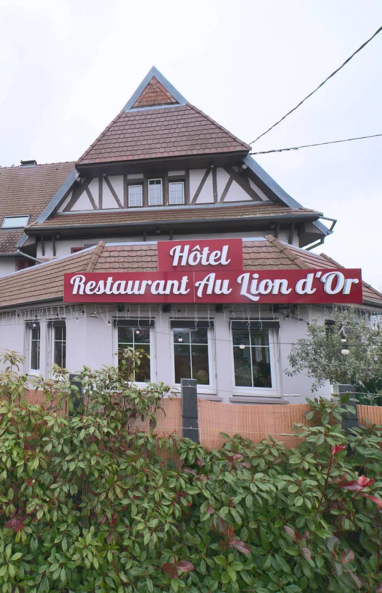 Representative hotel space: A hotel and restaurant building with a steep roof and sign above the entrance.