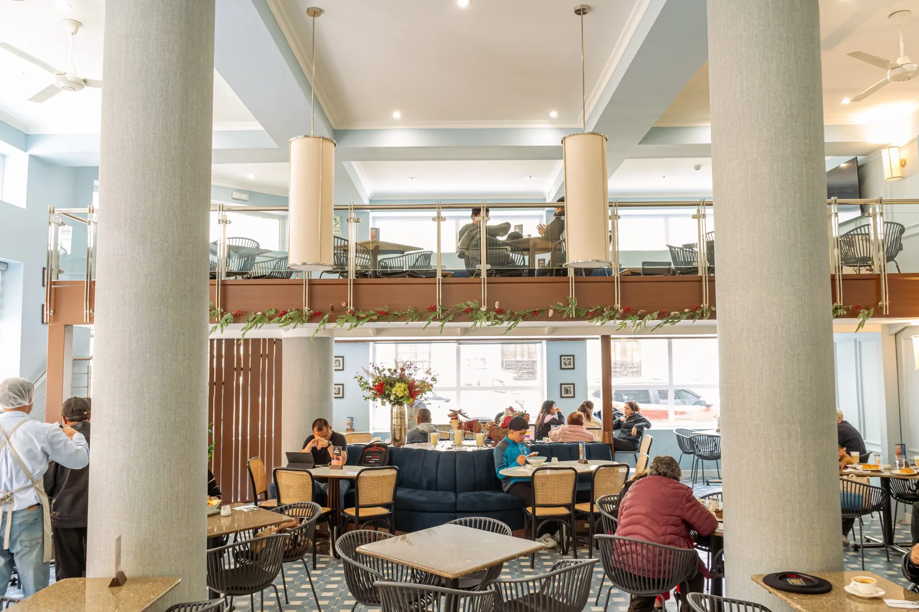Espacio representativo del hotel: Un comedor de restaurante con mesas, asientos y un espacio elevado.