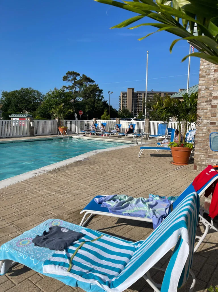 Representative hotel space: An outdoor swimming pool is surrounded by lounge chairs on a sunny deck.