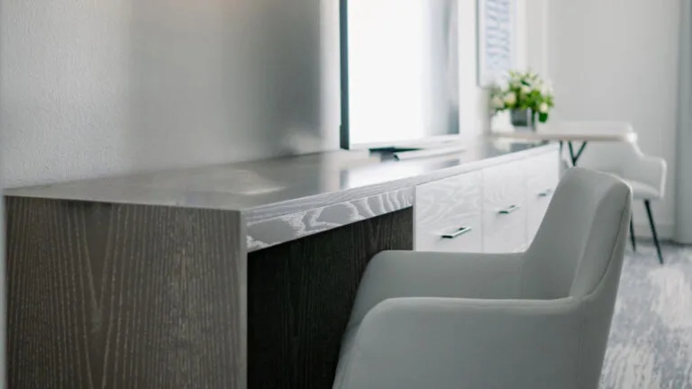 Representative hotel space: A desk with a chair sits beneath a window in a bright room.